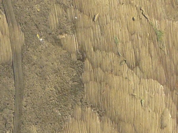 Rough metal texture in shiny, gold color with scratches and traces of welding on surface.