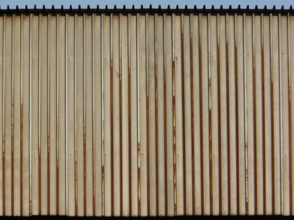 Old metal texture of lined, grey sheets of metal with slightly worn surface.