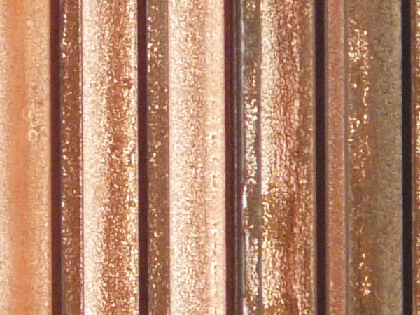Aged texture consisting of lined, metal siding with worn, rusting surface.