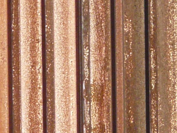 Aged texture consisting of lined, metal siding with worn, rusting surface.