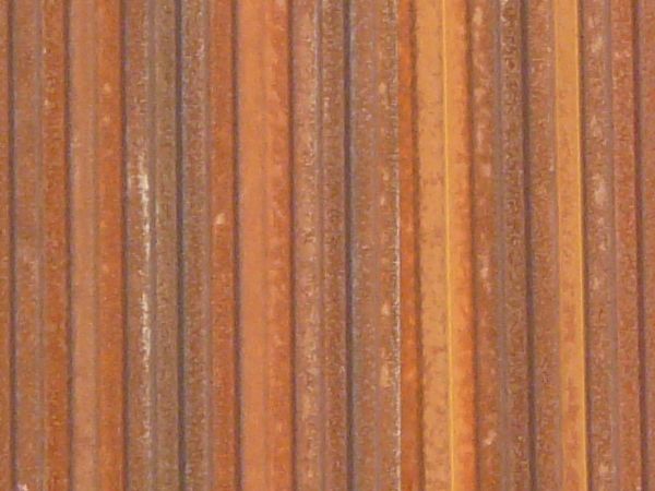 Aluminum siding in brown color with lined texture and slightly worn surface.