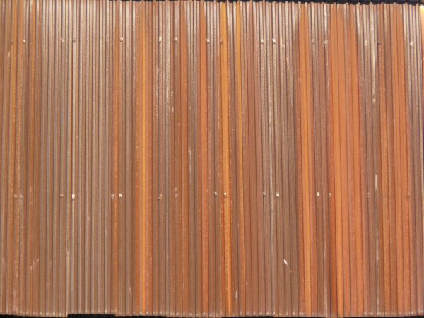 Aluminum siding in brown color with lined texture and slightly worn surface.