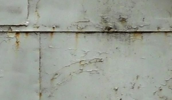 Old metal texture of large metal sheets with dents and rusting surface.
