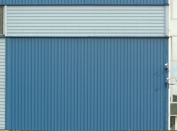 Texture of new metal siding painted in blue with lined texture.