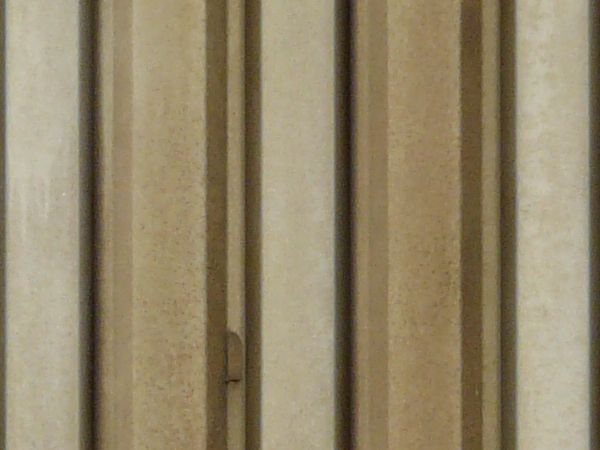 Metal texture in beige tone with vertical lined pattern and slightly worn surface.
