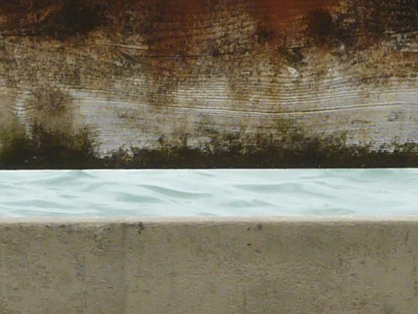 Old metal barrier with wooden planks and rusting surface.
