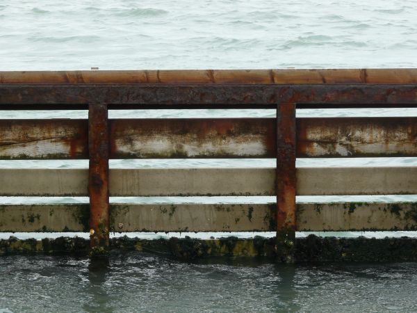 Old metal barrier with wooden planks and rusting surface.