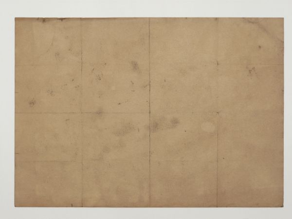 Tan paper texture with dark smudges and a pattern of large, folded rectangles.