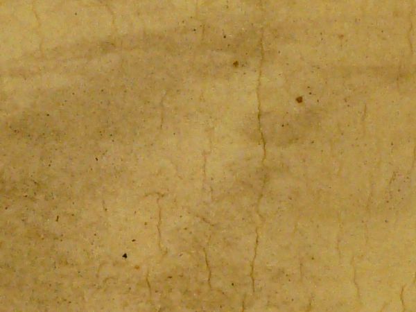 Old foam texture in pale yellow color with dark streaks and spots on surface.