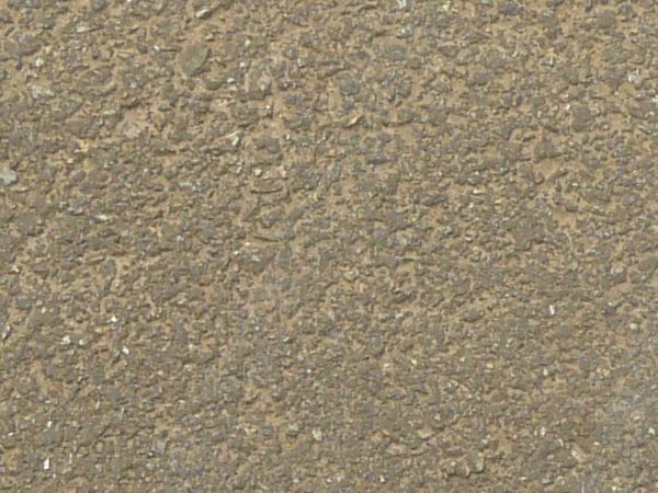 Road texture, sandy brown in color, with a large, irregularly shaped patch of dark asphalt on the center.