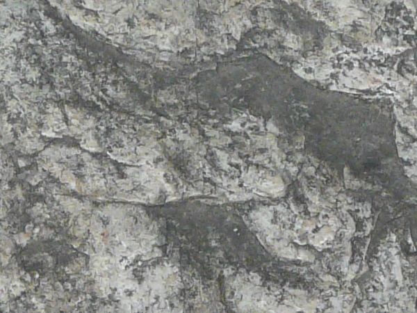 Texture of stone in various shades of grey with rough, irregular consistency.