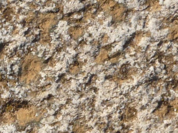 Stone texture in brown and pink tones with rough, jagged surface.