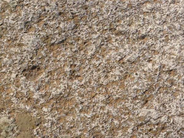 Stone texture in brown and pink tones with rough, jagged surface.