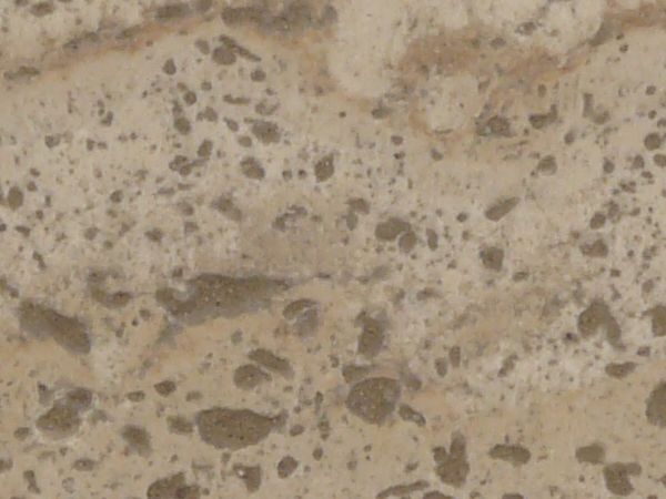 Stone texture in light beige tone with smooth surface and dark spots throughout.