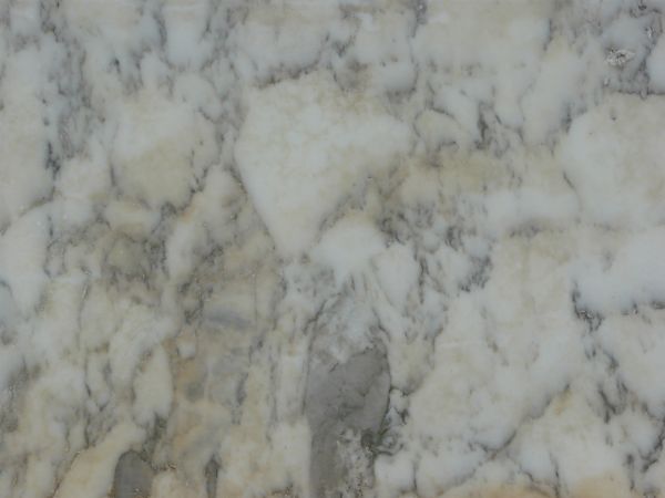 Smooth stone texture in white tone with dark lines in random patterns on surface.