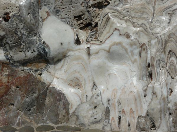 Cut section of stone in white and grey tones with random patterns on surface.