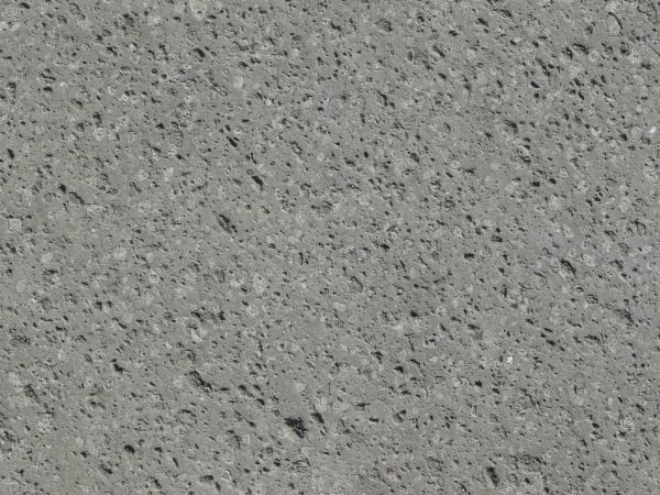 Flat stone texture in consistent, grey tone with small holes throughout surface.