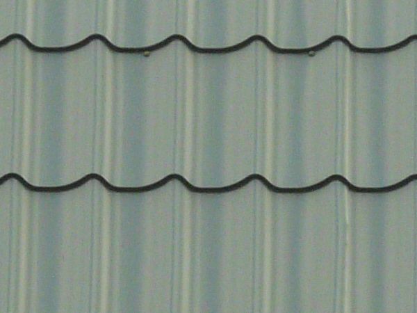 New roof made of dark blue, ruberoid-like shingles with curved edges.