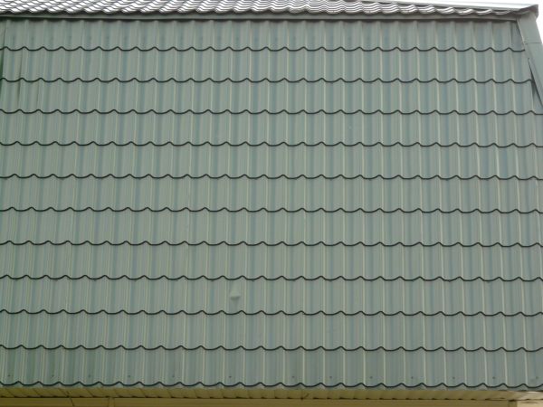 New roof made of dark blue, ruberoid-like shingles with curved edges.