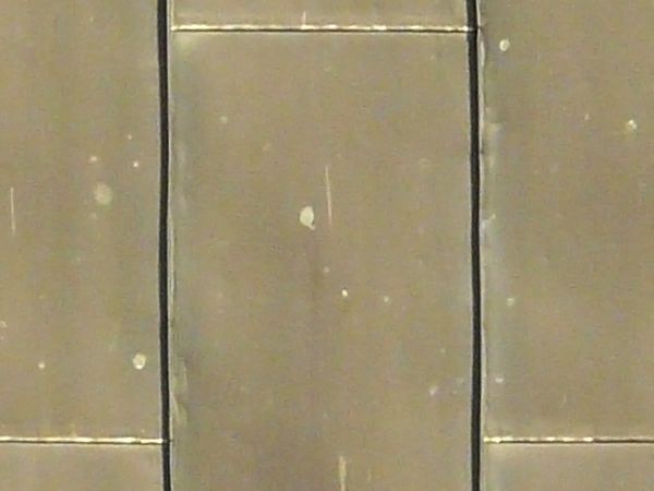 Roof texture consisting of flat, shiny metal sheets laid in repeating pattern.