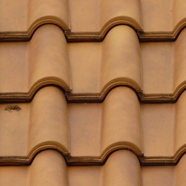 Roofing made of new, light brown shingles with rounded surfaces.