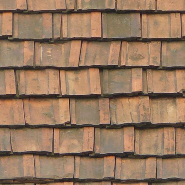 Old roof made of square, flat shingles in red and brown colors.