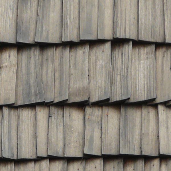 Roof made of grey wooden shingles set in unique pattern.