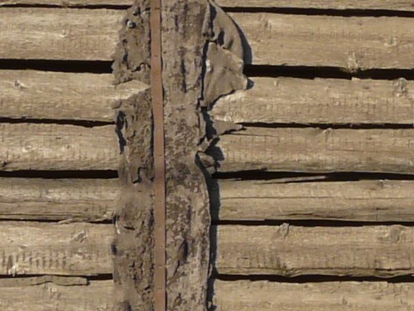Very old, decrepit roof of wooden planks with splintering edges and large holes.