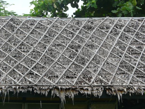 Roof texture consisting of dry grey grass with wooden planks in diamond pattern.