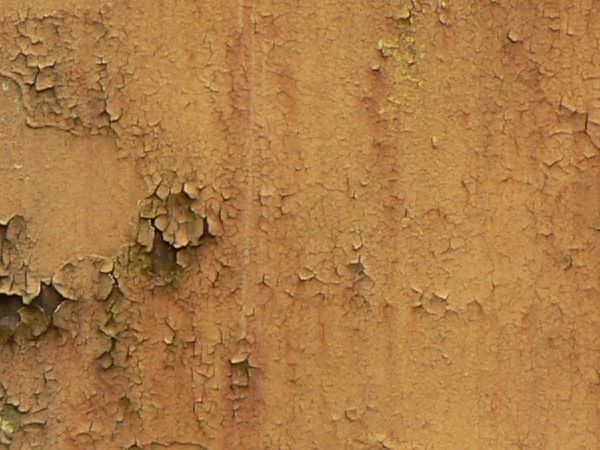 Red and white metal texture, with large chipping areas and completely covered by orange and brown rust stains.