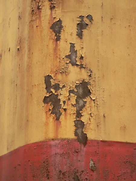 Red and white metal texture, with large chipping areas and completely covered by orange and brown rust stains.