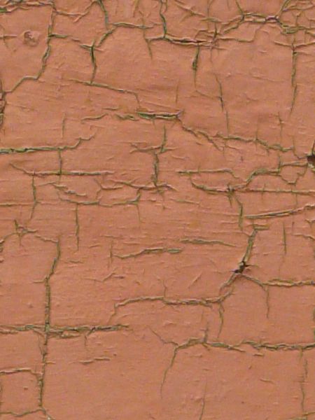 Chipping red paint texture, with rust stains faintly visible in the cracks.