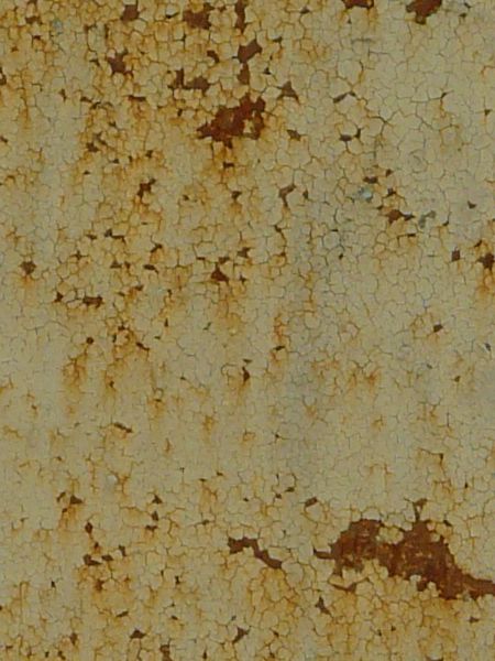Chipping white paint texture, with small rusted areas visible behind the chipped areas. Faint brown stains are also visible throughout.