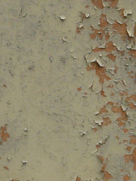 Tan painted metal texture with extensive chipping and peeling, and a surface of rusted metal visible underneath.