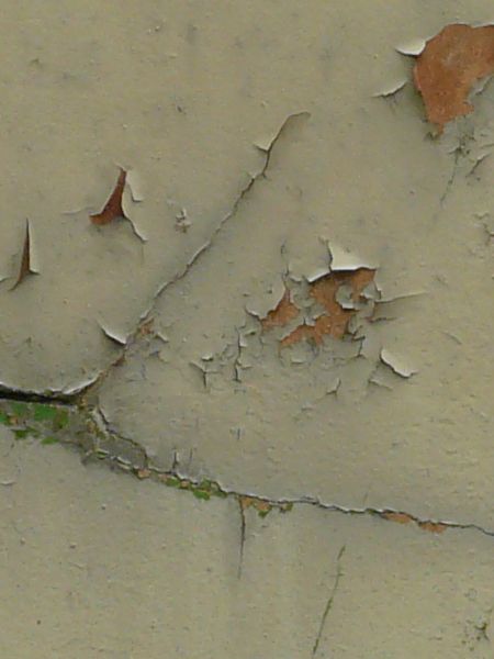 Tan painted metal texture with extensive chipping and peeling, and a surface of rusted metal visible underneath.