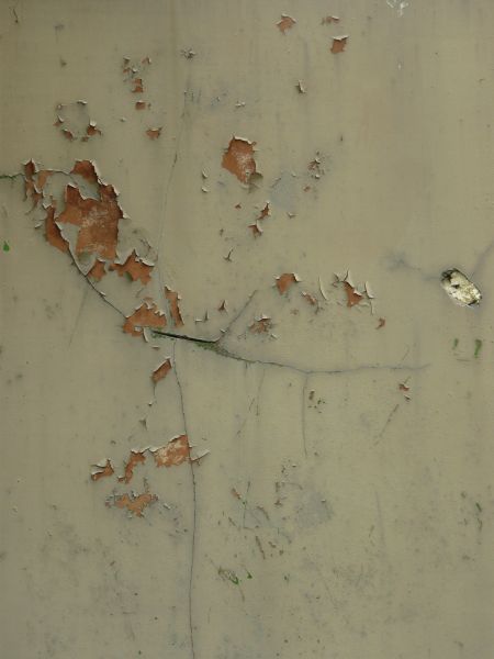 Tan painted metal texture with extensive chipping and peeling, and a surface of rusted metal visible underneath.