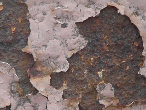 Pink painted metal texture, with several large chipped areas and heavy rust visible beneath.