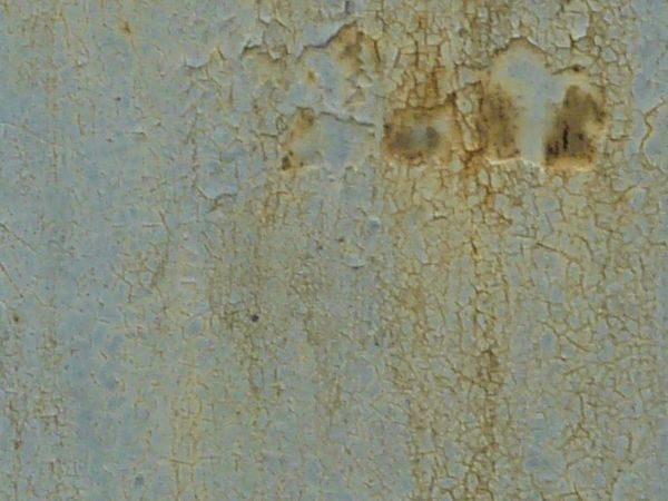 Grey painted metal texture, with extensive chipping and brown rust stains and marks throughout.