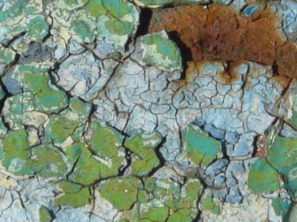 Green painted metal texture, with a rough, rusted surface beneath the chipping paint.