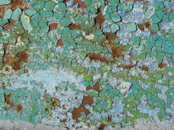 Green painted metal texture, with a rough, rusted surface beneath the chipping paint.