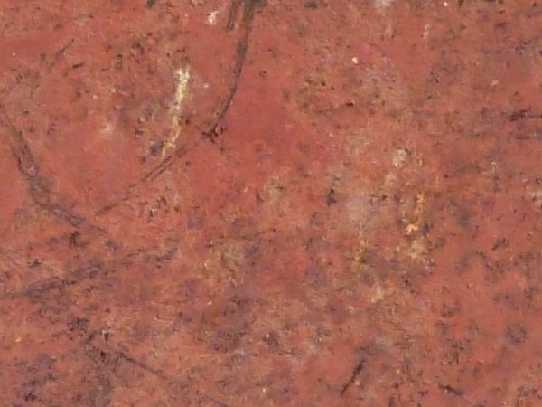 Red metal texture, covered with various red, grey and rusty brown scratches. Discolored and chipping areas are also visible.
