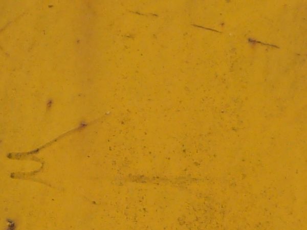 Yellow metal texture with various thin rust scratches and large rust stains visible througout.