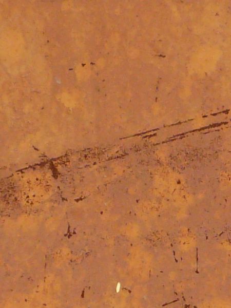 Thin rust scratches texture, scattered sparsely on a tan and yellow painted surface.