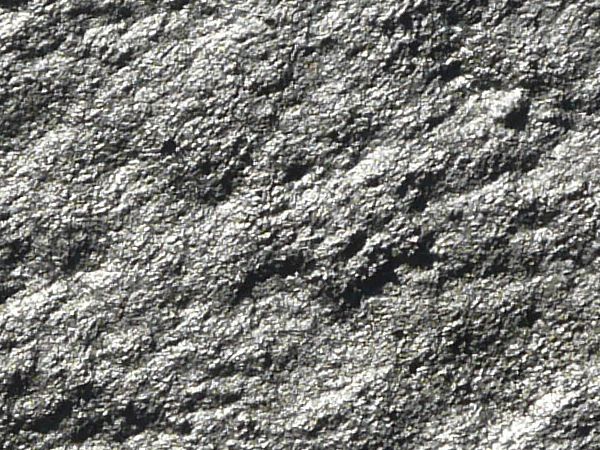 Hardened grey mud texture, dried into a smooth, porous and uneven surface.