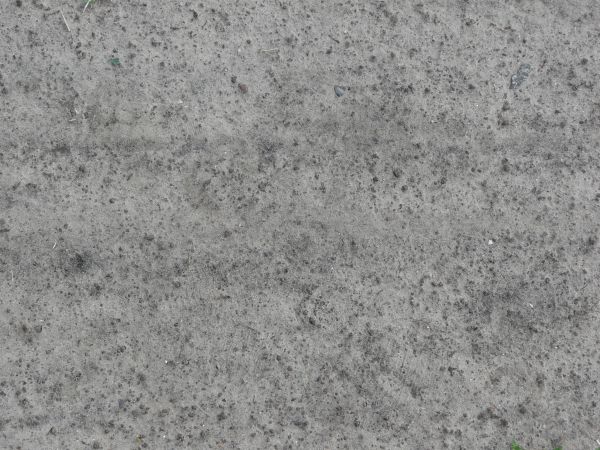 Grey sand texture, with areas of dark rock visible underneath.