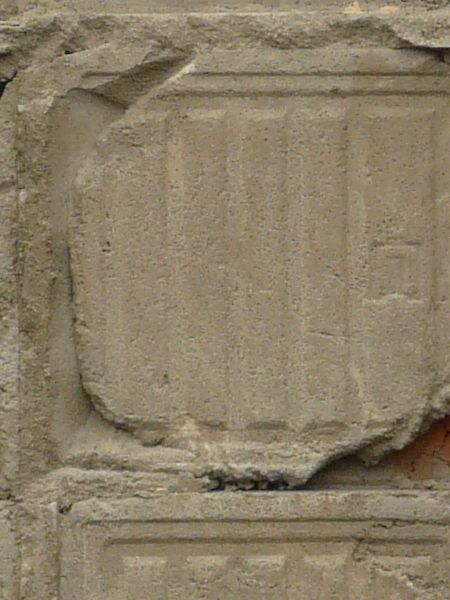 Texture of square brown-orange tiles partially covering deteriorating mortar wall with imprinted pattern.