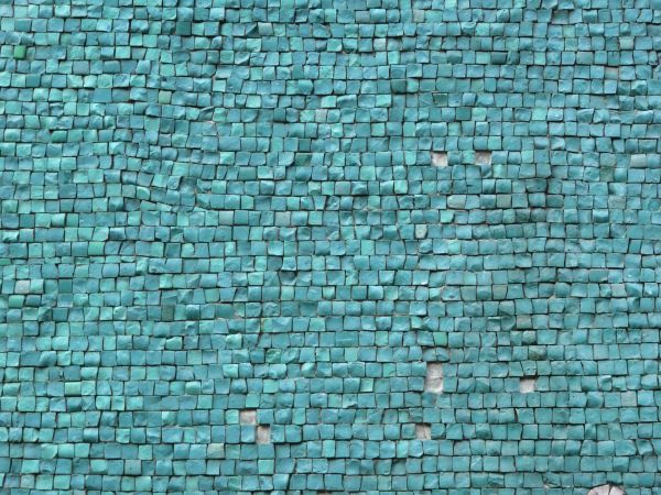 Small, square tiles in shiny, turquoise tones with extremely rough and irregular surfaces.