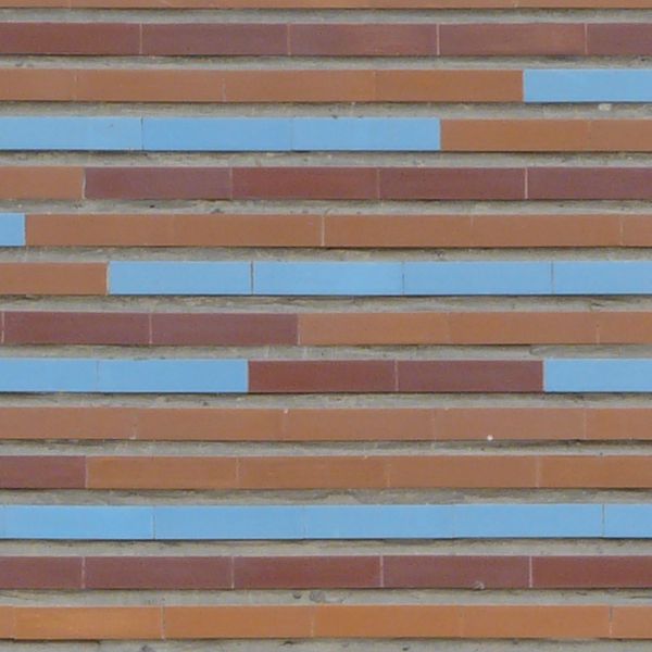 Seamless texture of long, narrow tiles in red tones with blue tiles placed randomly.