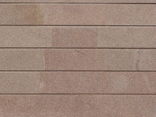 Siding of long tiles in dark red tone with horizontal seams and slightly dirty surface.