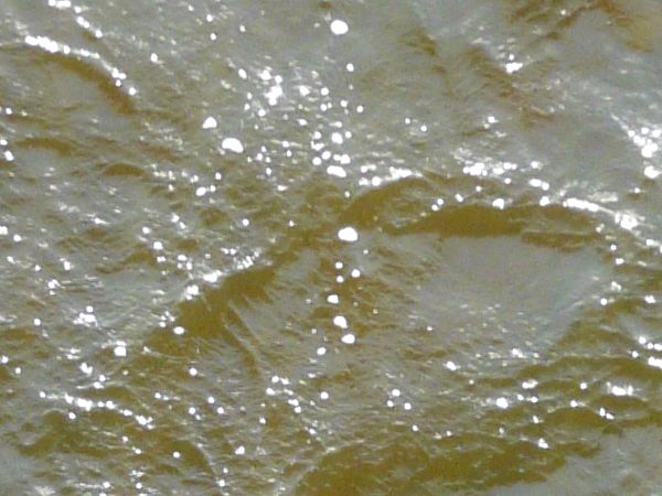 Dark water texture with myriads of small waves across surface.